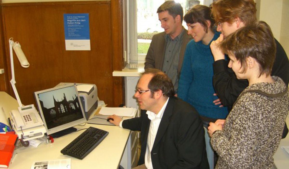 Eine Gruppe von Menschen vor einem PC