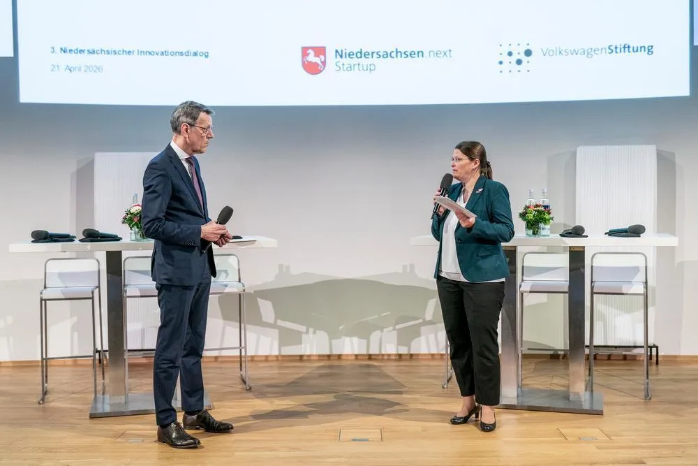 Eine Frau und ein Mann sprechen auf einer Bühne miteinander