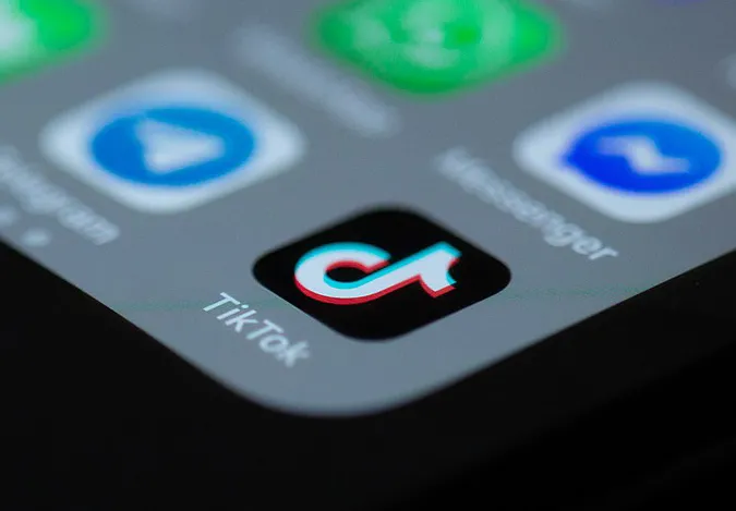 Apps auf einem Smartphone-Display sind sichtbar, im Zentrum die App TikTok