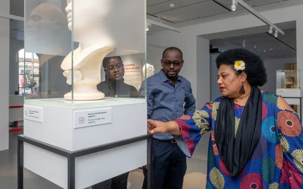 Drei Personen vor einer Ausstellungsvitrine
