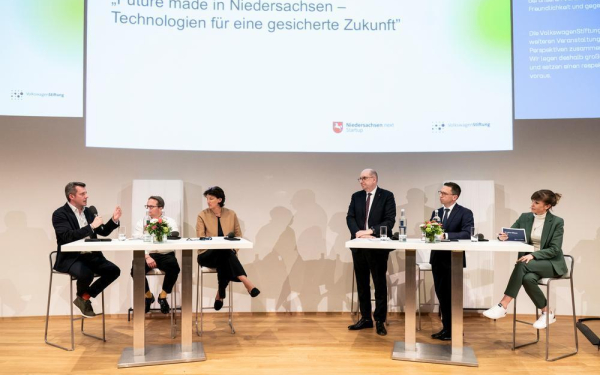 Sechs Menschen auf dem Podium unterhalten sich