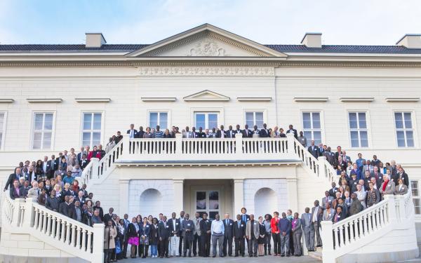 large group of people on stairs in front of a white representative building