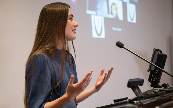 Woman on stage speaking into a microphone