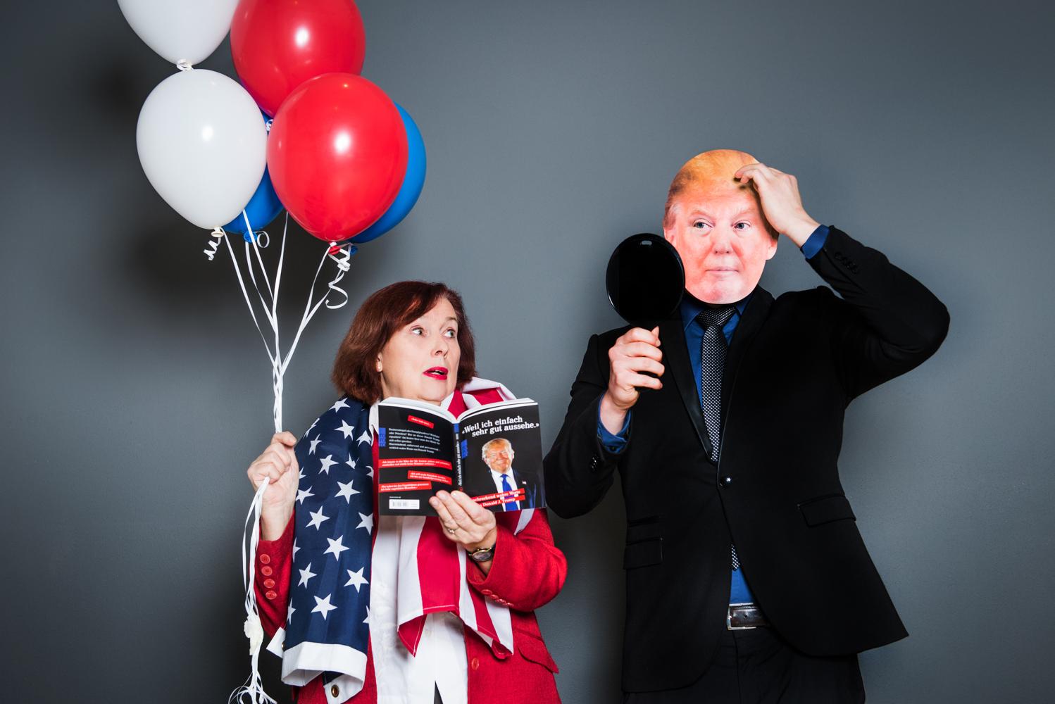 eine Person mit Trump-Maske und eine Frau mit weißen und roten Luftballons