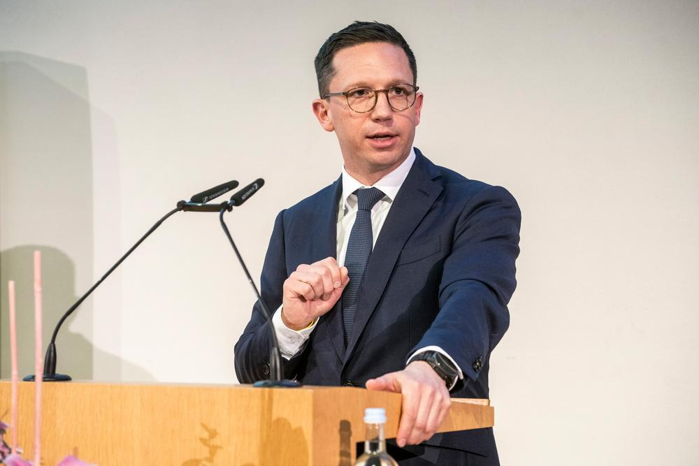 Ein Mann steht an einem Pult und hält einen Vortrag