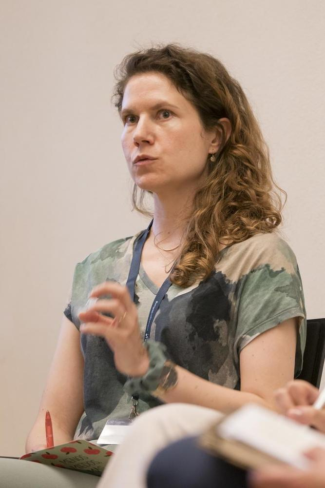Eine junge Wissenschaftlerin spricht auf einem Podium.