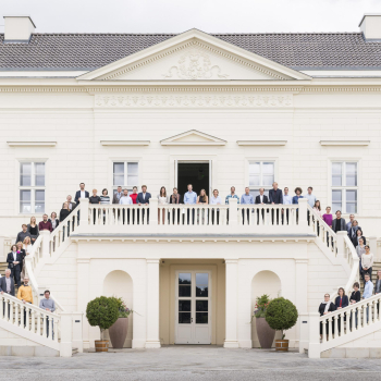 Das Bild zeigt eine Gruppe von Personen, die vor Schloss Herrenhausen in Hannover aufgestellt sind.