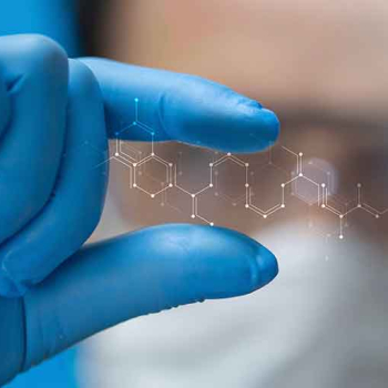 Das Bild zeigt eine Hand in einem sterilem, blauen Handschuh, die eine durchsichtige Nanostruktur hochhält.