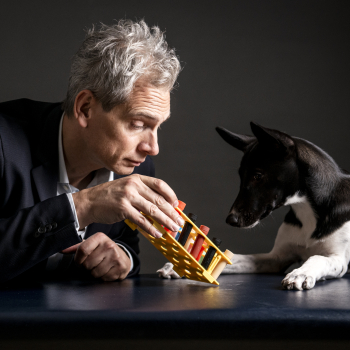 Das Bild zeigt Prof. Holger Volk mit Spürhund, der an Duftröhrchen riecht