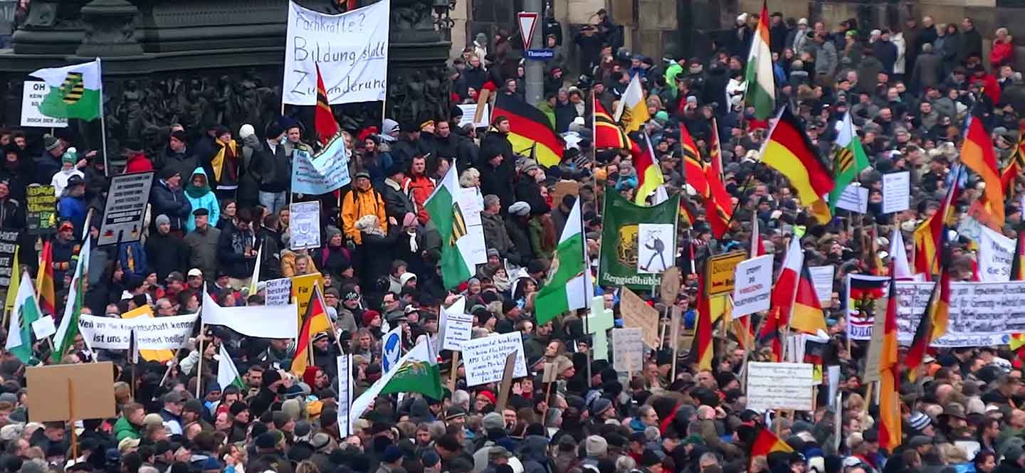 Demonstrierende Menschen mit Fahnen und Plakaten