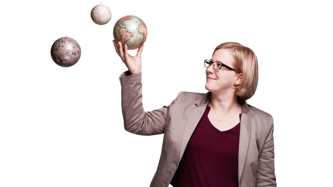 Carolin Antos hält Weltkugeln.